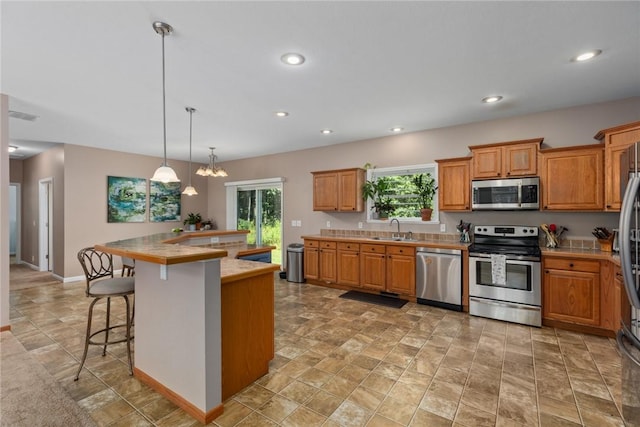 485 County Road 600 N, Neoga, IL 62447 - kitchen featuring stainless steel appliances, a kitchen bar, light countertops, recessed lighting, and hanging light fixtures