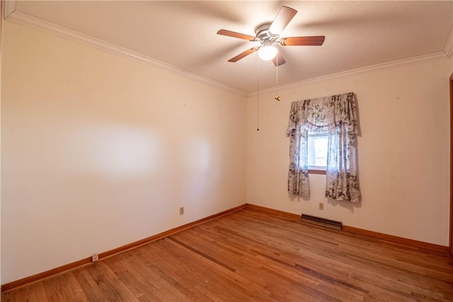 empty room featuring ornamental molding, visible vents, light wood-style flooring, and baseboards