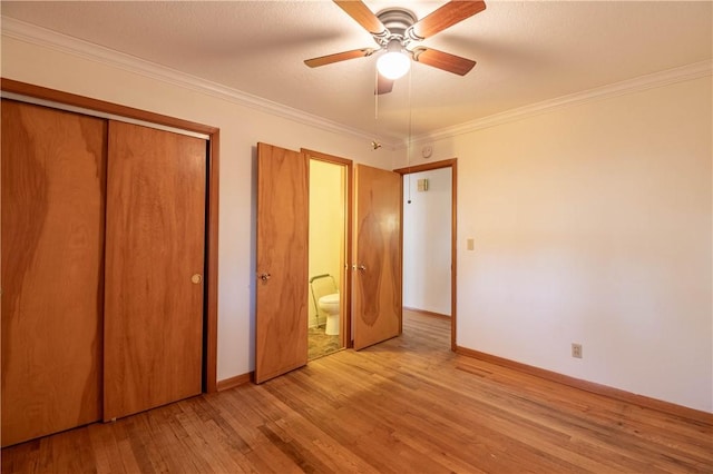 unfurnished bedroom featuring a closet, ornamental molding, ceiling fan, wood finished floors, and baseboards