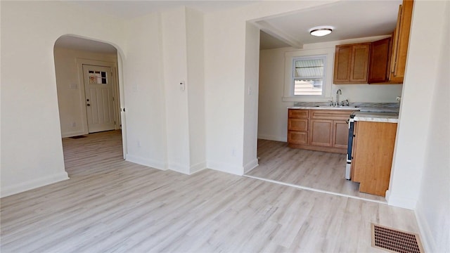 2198 Hendrix St, Decatur, IL 62521 - kitchen featuring stainless steel stove, light countertops, arched walkways, and brown cabinets