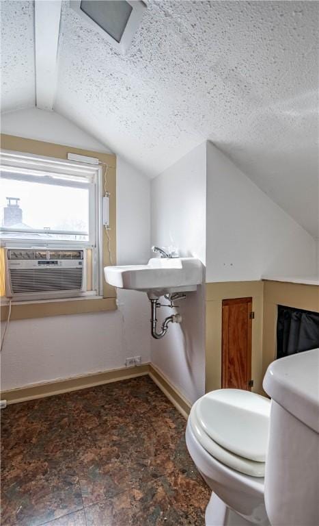 bathroom with lofted ceiling, cooling unit, toilet, and a textured ceiling