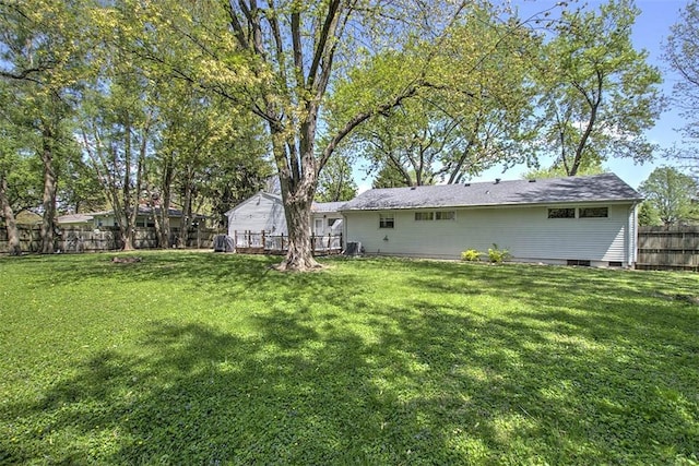 rear view of property featuring fence, a yard, and a deck
