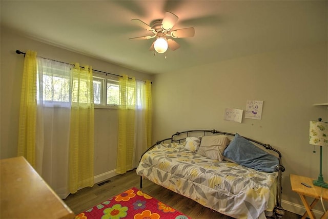 bedroom with ceiling fan, baseboards, visible vents, and wood finished floors