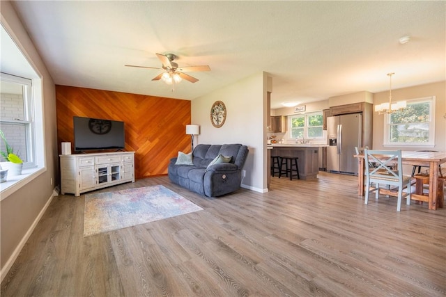 1203 Temple Ave, Effingham, IL 62401 - living room with a ceiling fan, light wood finished floors, a chandelier, and wooden walls