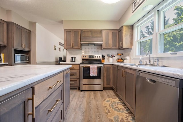1203 Temple Ave, Effingham, IL 62401 - kitchen featuring stainless steel appliances, light wood finished floors, tasteful backsplash, light stone countertops, and range hood