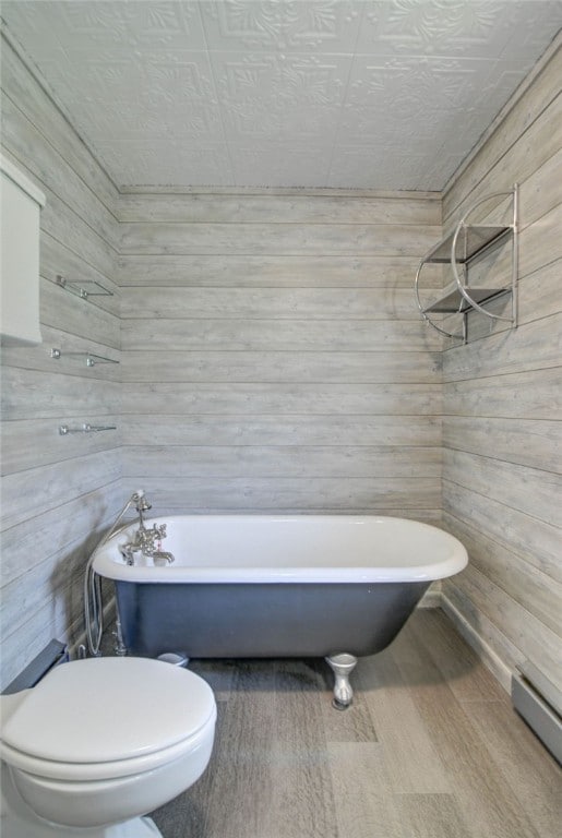 319 N Macon St, Moweaqua, IL 62550 - full bath with wood walls, a soaking tub, wood finished floors, and a baseboard radiator