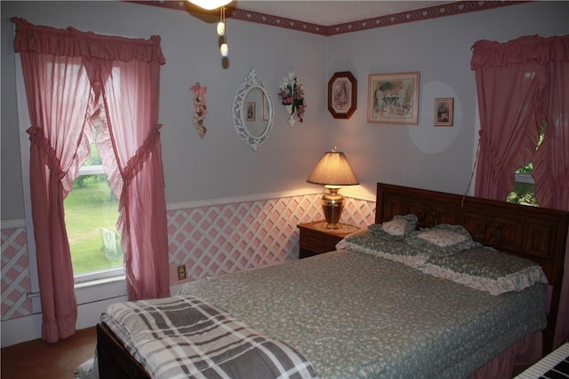 235 E 150 N Rd, Hammond, IL 61929 - bedroom with multiple windows, wallpapered walls, and wainscoting