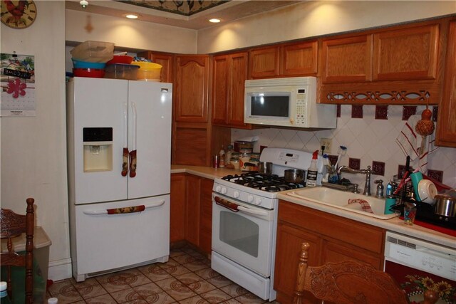 235 E 150 N Rd, Hammond, IL 61929 - kitchen with white appliances, brown cabinetry, light countertops, and tasteful backsplash