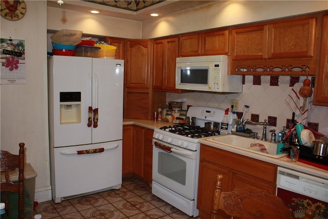 235 E 150 N Rd, Hammond, IL 61929 - kitchen with white appliances, brown cabinetry, light countertops, and tasteful backsplash