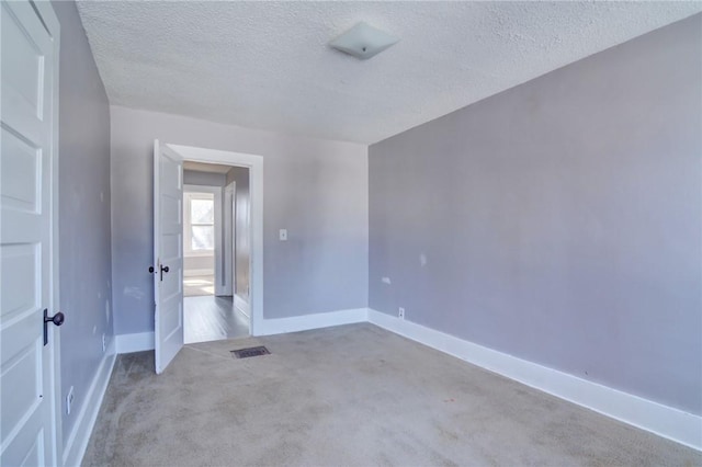 carpeted spare room with a textured ceiling