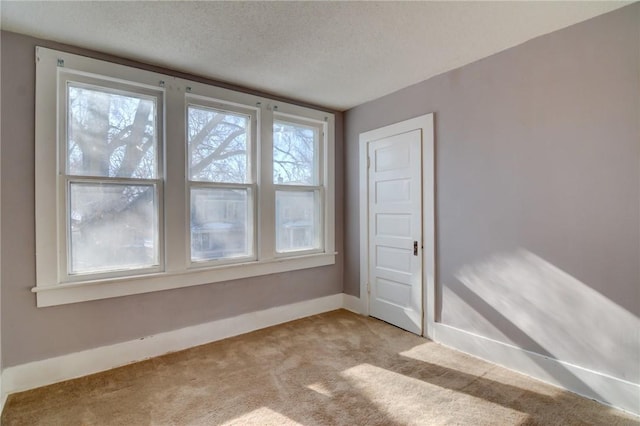 carpeted spare room with a textured ceiling