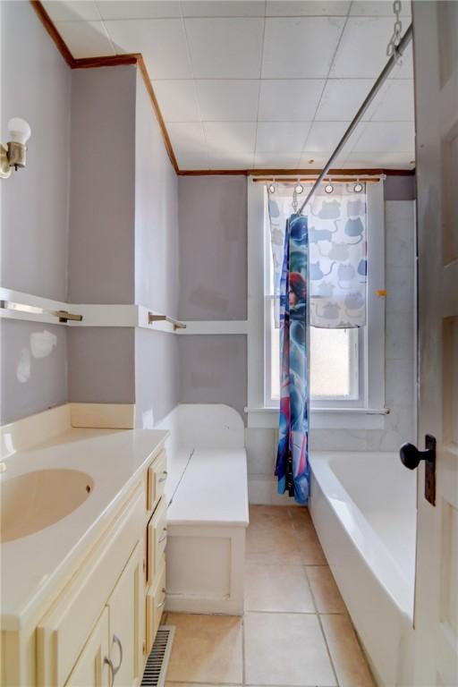 bathroom featuring tile patterned flooring, vanity, and shower / tub combo with curtain