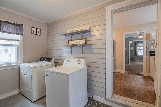 washroom featuring separate washer and dryer, ceiling fan, and wood walls