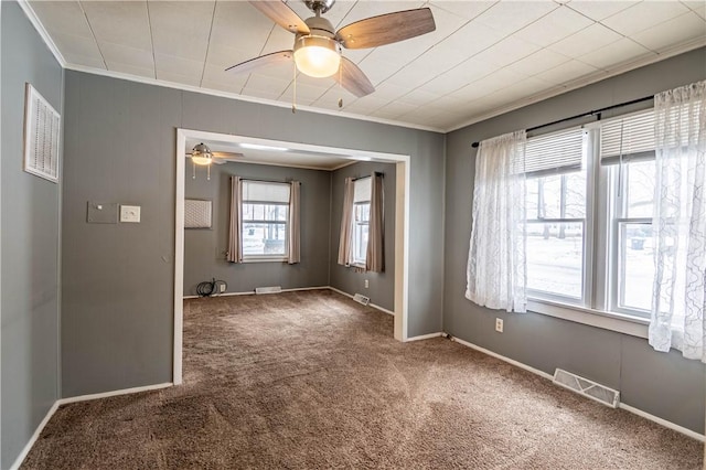 empty room featuring crown molding, carpet floors, and a wealth of natural light