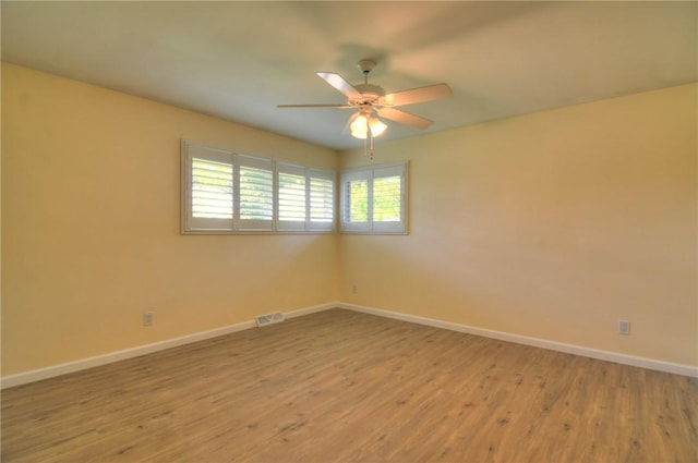 unfurnished room featuring baseboards, ceiling fan, light wood-type flooring, and visible vents