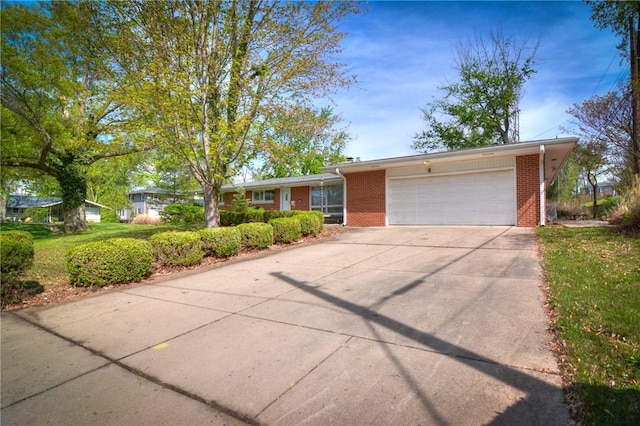 single story home featuring a garage, driveway, and brick siding