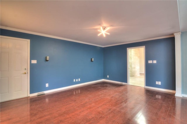 spare room featuring crown molding, baseboards, and wood finished floors