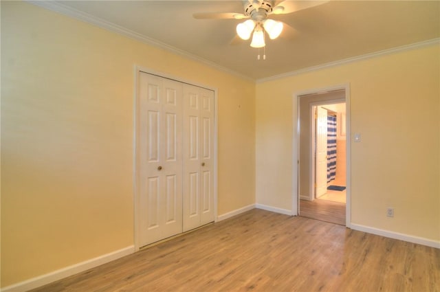 unfurnished bedroom with crown molding, baseboards, a closet, and light wood-type flooring