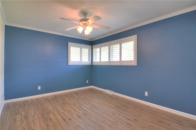 empty room featuring a ceiling fan, baseboards, and ornamental molding