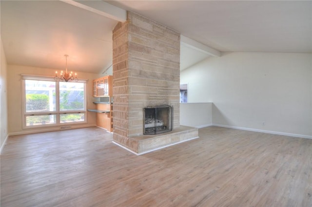 unfurnished living room featuring vaulted ceiling with beams, wood finished floors, a fireplace, and an inviting chandelier