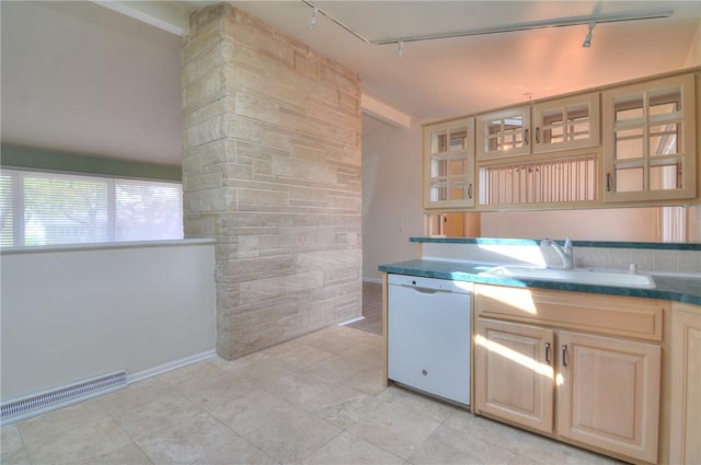 kitchen featuring visible vents, white dishwasher, rail lighting, a sink, and glass insert cabinets