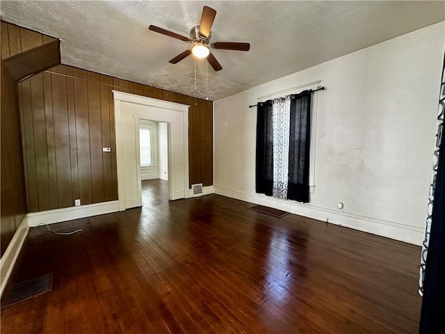 996 W Packard St, Decatur, IL 62522 - unfurnished room featuring a ceiling fan, hardwood / wood-style flooring, a textured ceiling, and wood walls