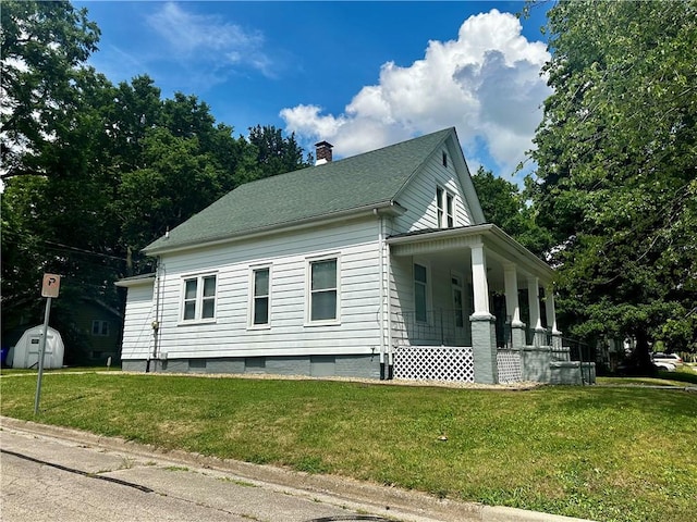 996 W Packard St, Decatur, IL 62522 - view of side of property featuring a porch, a storage shed, a yard, and a chimney