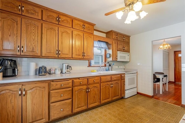 2417 Maple Ave, Decatur, IL 62526 - kitchen featuring white appliances, brown cabinetry, ceiling fan, light countertops, and a chandelier