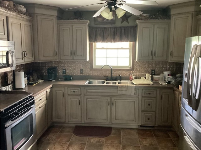kitchen featuring a sink, ceiling fan, appliances with stainless steel finishes, and decorative backsplash