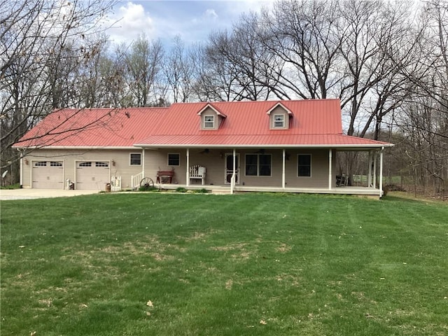 view of front facade with a porch, metal roof, a garage, a front lawn, and driveway