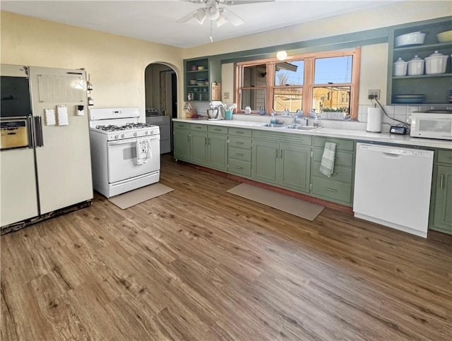 kitchen featuring light countertops, white appliances, a sink, and green cabinetry