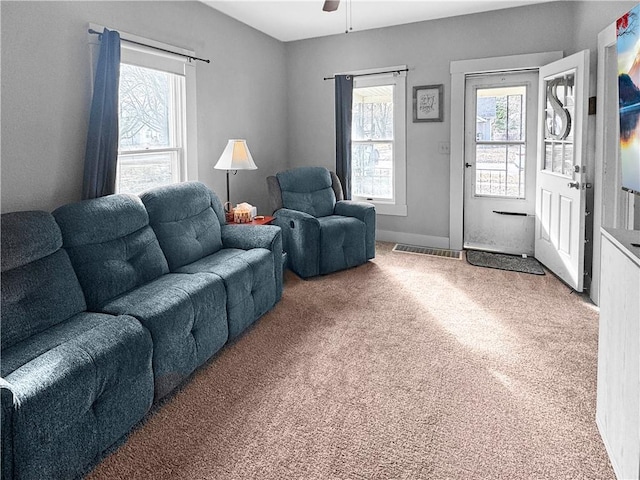 carpeted living area with ceiling fan and visible vents