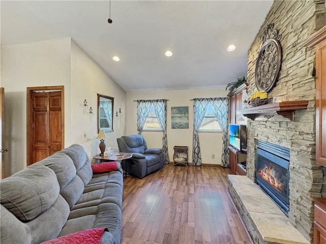 living area featuring recessed lighting, vaulted ceiling, a fireplace, and wood finished floors