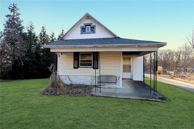 exterior space with a porch, a lawn, and roof with shingles