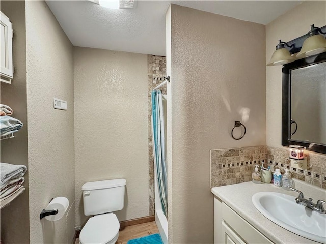 bathroom featuring a textured wall, toilet, vanity, decorative backsplash, and shower / bath combo with shower curtain