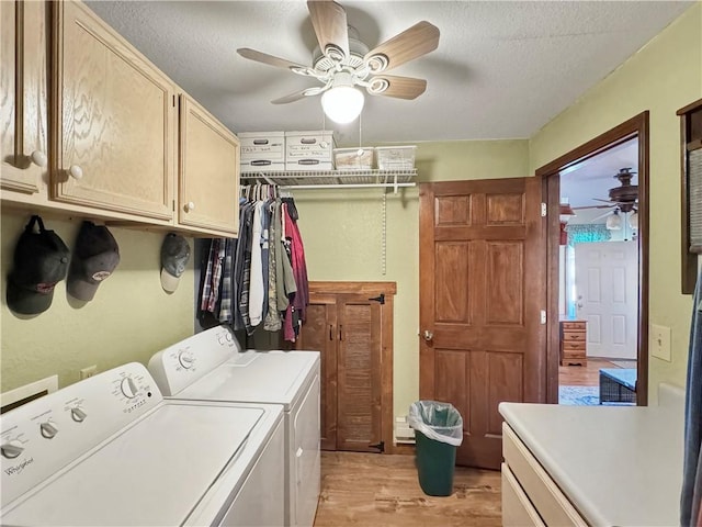 laundry room featuring a textured ceiling, light wood-style flooring, cabinet space, and washer and dryer