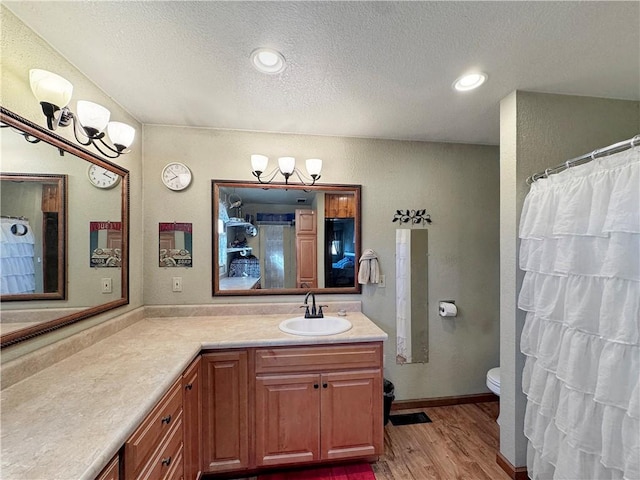 full bathroom featuring a textured ceiling, toilet, recessed lighting, wood finished floors, and vanity