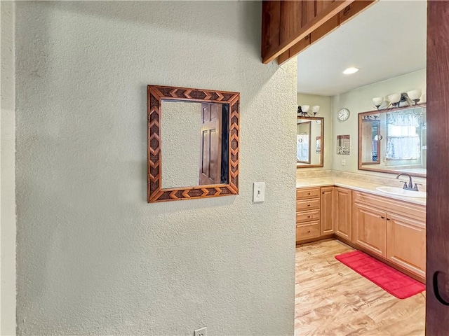 bathroom featuring a textured wall, wood finished floors, and vanity