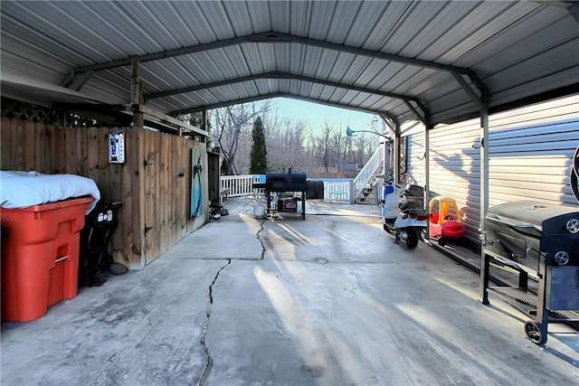 view of vehicle parking with fence and a detached carport