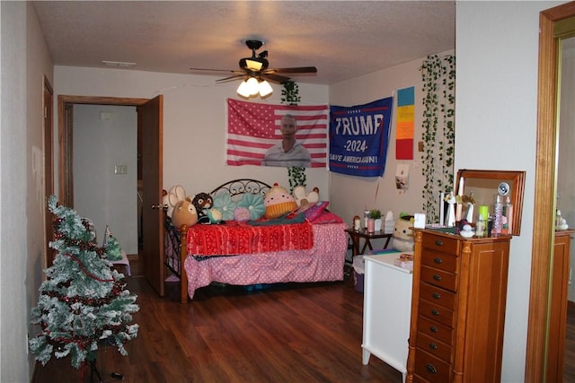 bedroom with ceiling fan, dark hardwood / wood-style flooring, and a textured ceiling