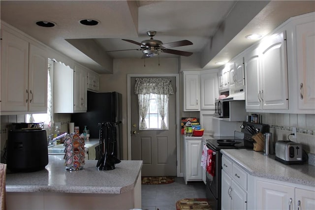 kitchen featuring white cabinetry, tasteful backsplash, kitchen peninsula, ceiling fan, and black appliances