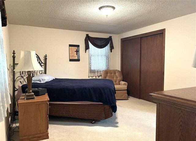 601 Holiday Dr, Effingham, IL 62401 - bedroom featuring a closet, light carpet, and a textured ceiling