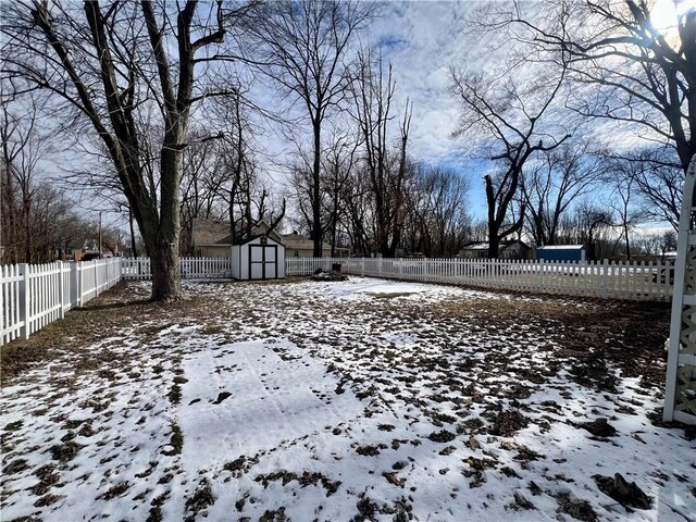 snowy yard with a storage shed