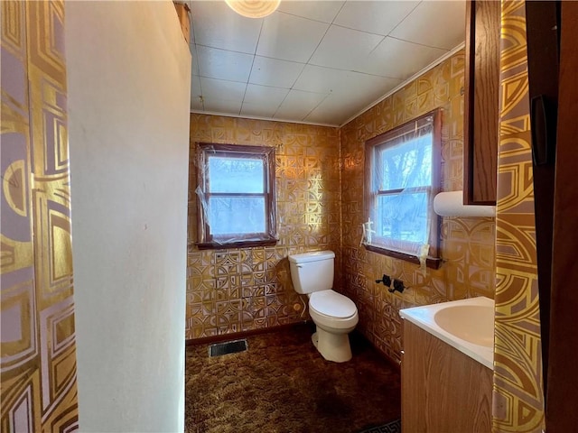 bathroom with a tub to relax in and toilet