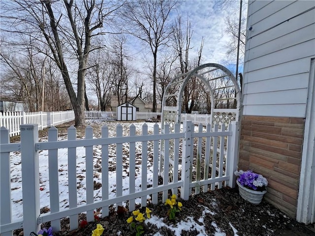 yard covered in snow with a storage unit