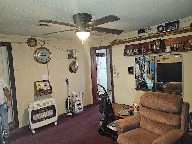 carpeted office with heating unit and ceiling fan