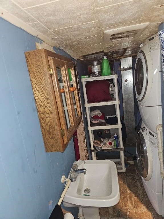 laundry room featuring stacked washer and dryer and sink