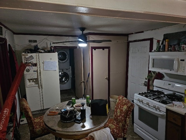 kitchen featuring ceiling fan, white appliances, and stacked washer / dryer