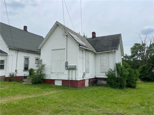 rear view of property featuring a lawn