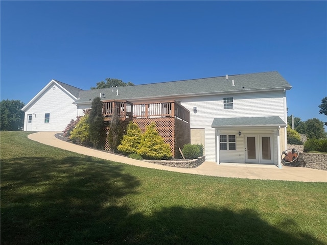 rear view of property featuring a lawn, a deck, and a patio